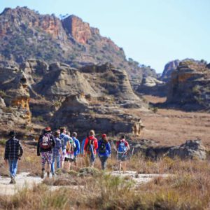 Isalo, Madagascar - August 2, 2015: A group of tourists hike across the arid plateau of the Isalo National Park. The area is very popular with tourists in search of unusual landscapes and unique wildlife.